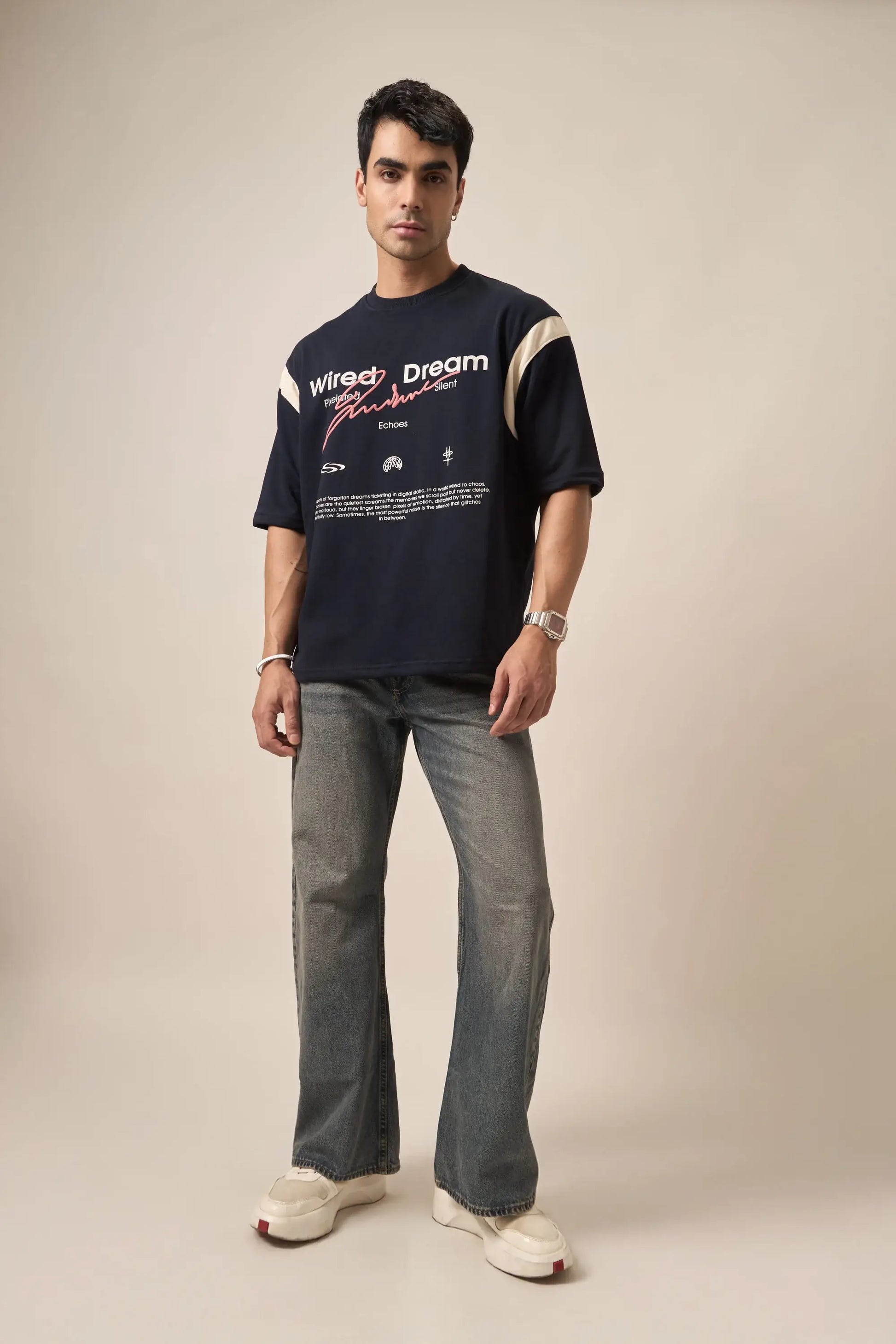 Man wearing a navy t-shirt with text and graphics, standing against a plain background
