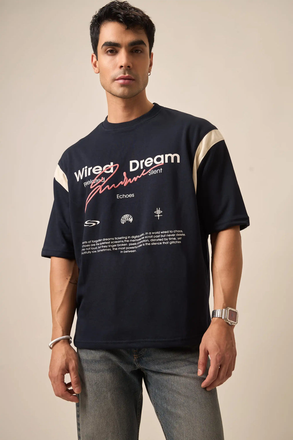 Man wearing a navy t-shirt with text and logos on a beige background