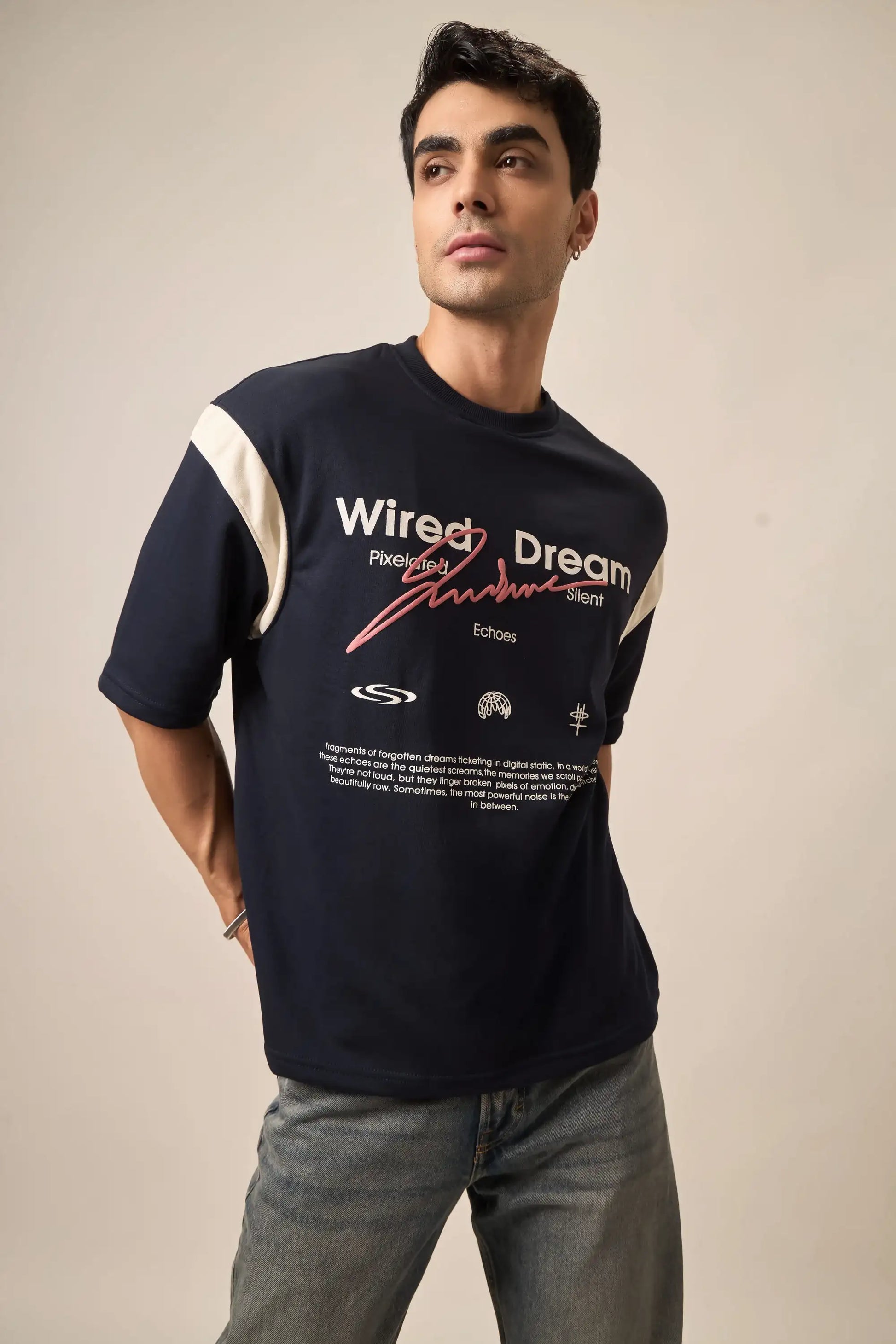 Man wearing the dream t-shirt with text and logos on a beige background