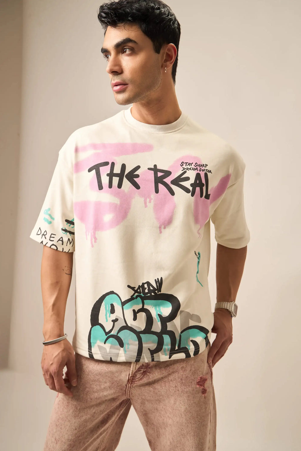 Person wearing a t-shirt with colorful graphics and text on a plain background