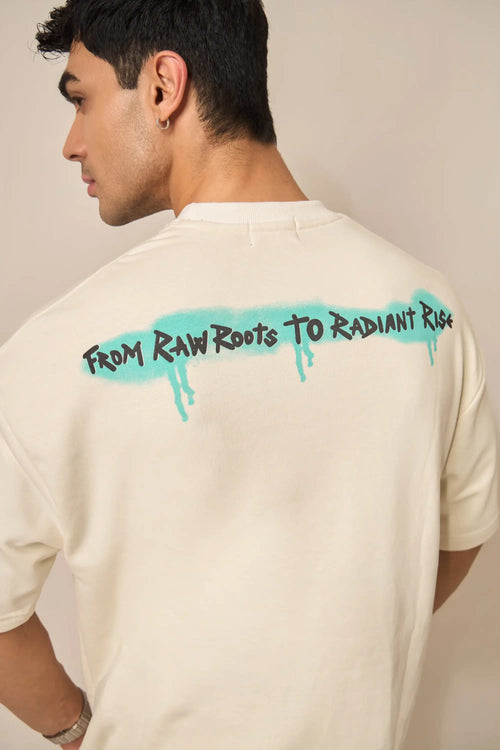 Person wearing a cream t-shirt with graffiti designed text on the back against a neutral background