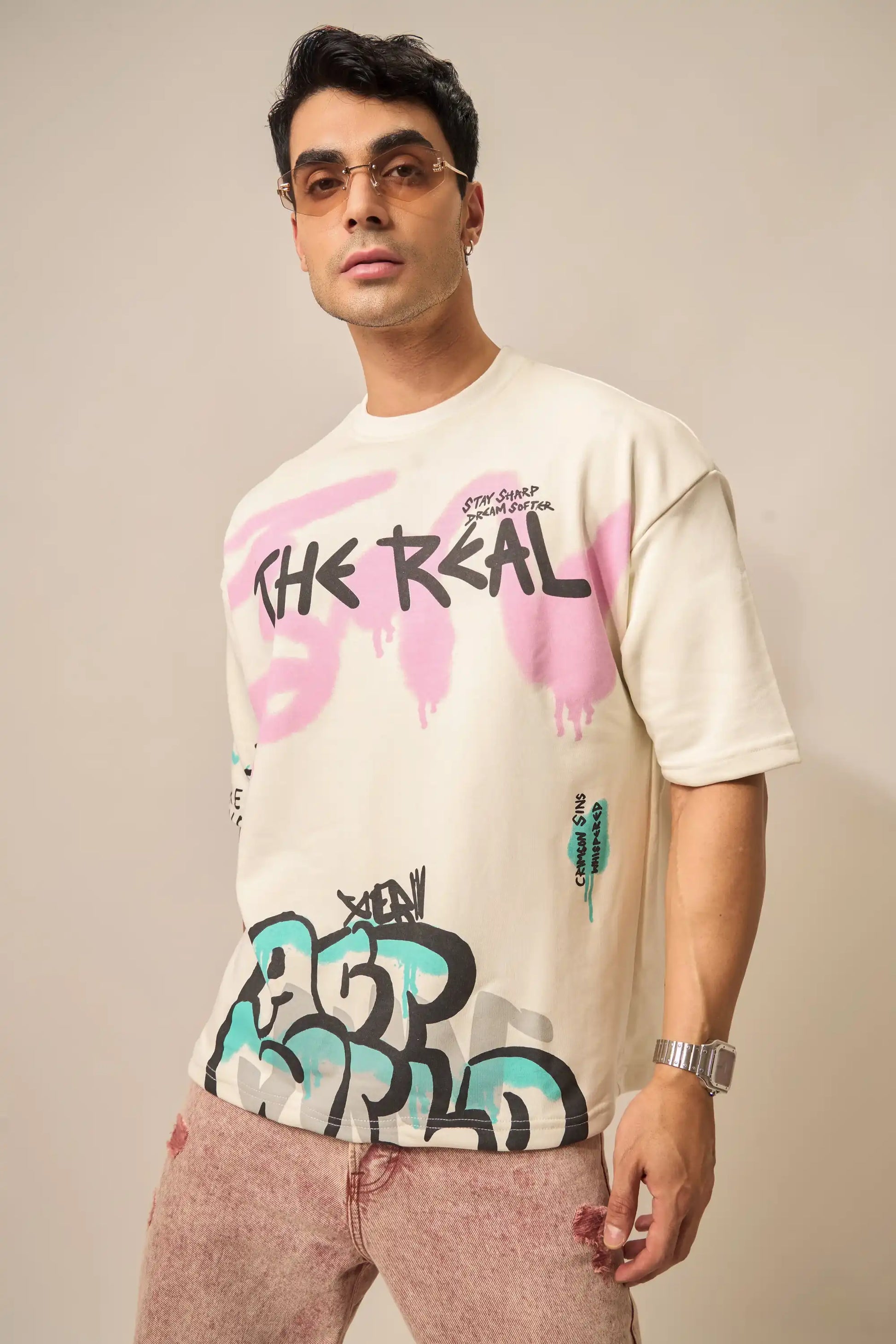 Man wearing a white t-shirt with colorful graphics and text against a plain background
